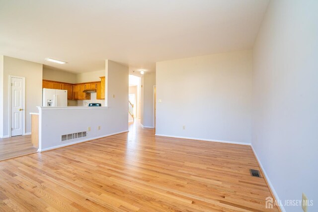 17 Larkspur Dr, South Brunswick, NJ 08810 - unfurnished living room featuring visible vents, baseboards, and light wood-style floors