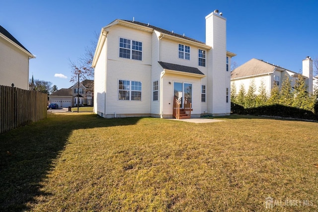 17 Larkspur Dr, South Brunswick, NJ 08810 - rear view of house with fence, entry steps, a chimney, and a lawn
