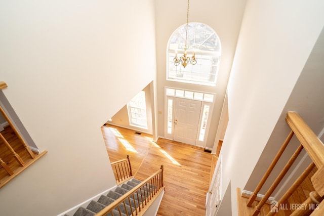17 Larkspur Dr, South Brunswick, NJ 08810 - foyer featuring visible vents, a high ceiling, a chandelier, stairway, and light wood-style flooring