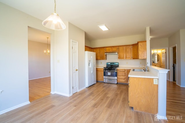 17 Larkspur Dr, South Brunswick, NJ 08810 - kitchen with light countertops, white refrigerator with ice dispenser, under cabinet range hood, light wood finished floors, and stainless steel range with gas cooktop