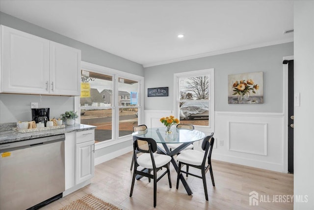 dining room featuring recessed lighting, wainscoting, ornamental molding, light wood finished floors, and visible vents