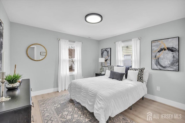 bedroom with light wood-style flooring and baseboards