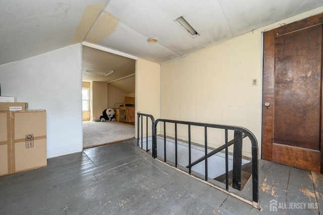 hallway with an upstairs landing and lofted ceiling