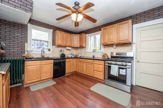 kitchen with brick wall, stainless steel gas stove, dishwasher, a sink, and dark wood-type flooring