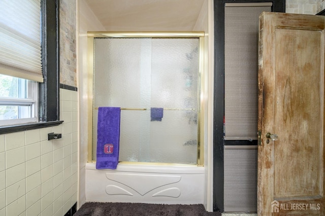 full bathroom with bath / shower combo with glass door