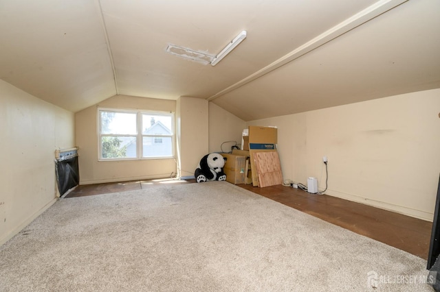 additional living space featuring carpet floors, baseboards, and vaulted ceiling