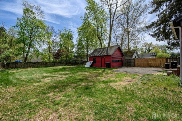 view of yard with fence, an outbuilding, and a detached garage