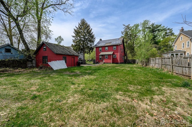 view of yard with entry steps, fence, an outdoor structure, and a storage shed