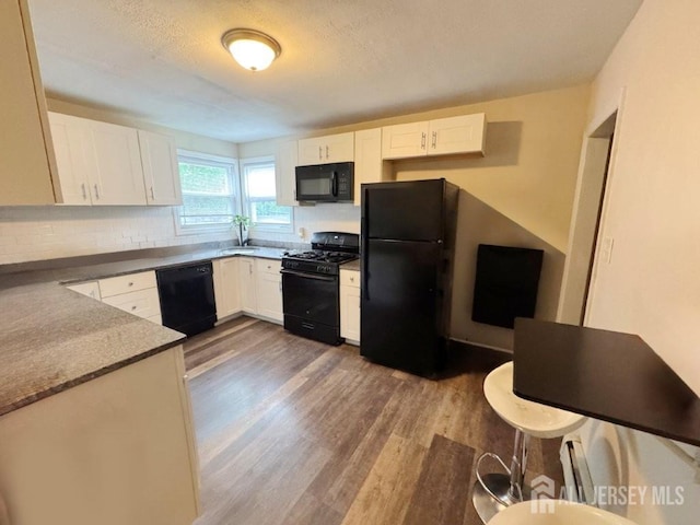 10 S 8th Ave S, Highland Park, NJ 08904 - kitchen featuring black appliances, dark wood finished floors, white cabinetry, and a textured ceiling