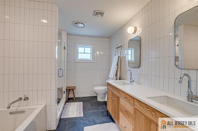 12 S 8th Ave, Highland Park, NJ 08904 - full bathroom featuring tile walls, toilet, a shower stall, a bath, and double vanity