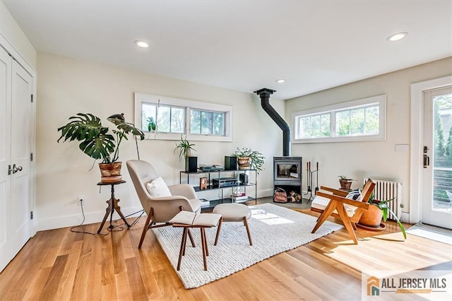 12 S 8th Ave, Highland Park, NJ 08904 - sitting room featuring a wood stove, light wood-style floors, radiator heating unit, baseboards, and recessed lighting