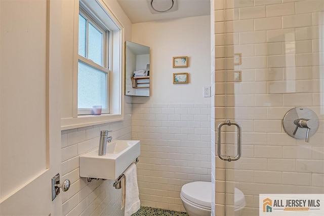 12 S 8th Ave, Highland Park, NJ 08904 - bathroom with tile walls, a sink, wainscoting, a shower stall, and toilet