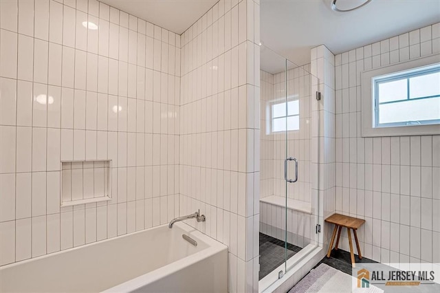 12 S 8th Ave, Highland Park, NJ 08904 - bathroom featuring a shower stall, a tub to relax in, tile walls, and healthy amount of natural light