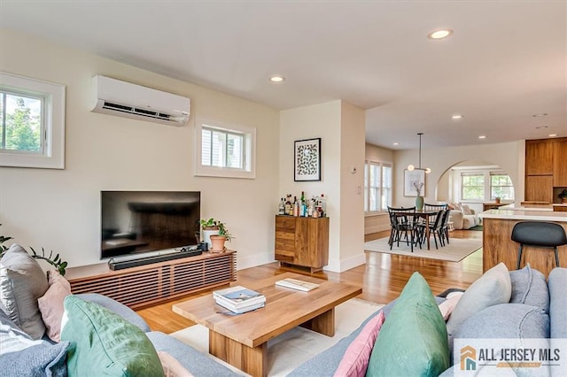 12 S 8th Ave, Highland Park, NJ 08904 - living area with a wall mounted air conditioner, arched walkways, plenty of natural light, recessed lighting, and light wood-style flooring