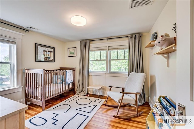 12 S 8th Ave, Highland Park, NJ 08904 - bedroom with light wood-style flooring, baseboards, and a nursery area