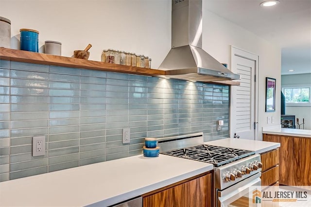 12 S 8th Ave, Highland Park, NJ 08904 - kitchen featuring stainless steel gas range oven, brown cabinetry, range hood, decorative backsplash, and modern cabinets
