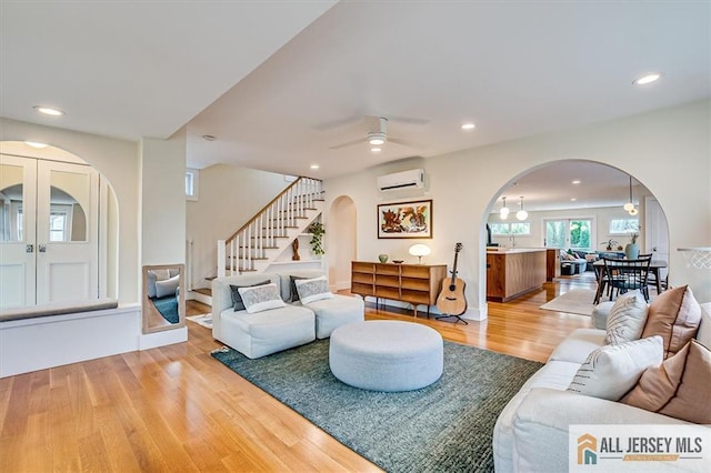 12 S 8th Ave, Highland Park, NJ 08904 - living area with arched walkways, a wall mounted air conditioner, light wood-style flooring, stairs, and recessed lighting