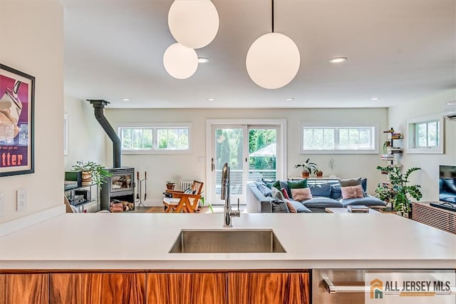 12 S 8th Ave, Highland Park, NJ 08904 - kitchen featuring a sink, open floor plan, a wood stove, plenty of natural light, and recessed lighting