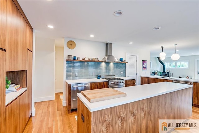 12 S 8th Ave, Highland Park, NJ 08904 - kitchen featuring modern cabinets, wall chimney exhaust hood, appliances with stainless steel finishes, brown cabinetry, and light countertops