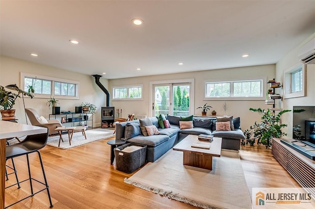 12 S 8th Ave, Highland Park, NJ 08904 - living area with a wood stove, recessed lighting, light wood finished floors, and a wall mounted AC