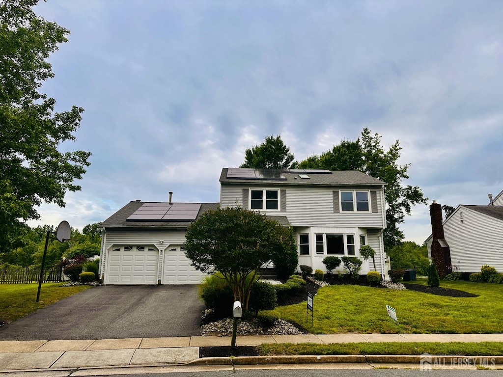 32 Wetherhill Way S, Brunswick, NJ 08810 - colonial-style house with a front lawn, a garage, solar panels, and asphalt driveway
