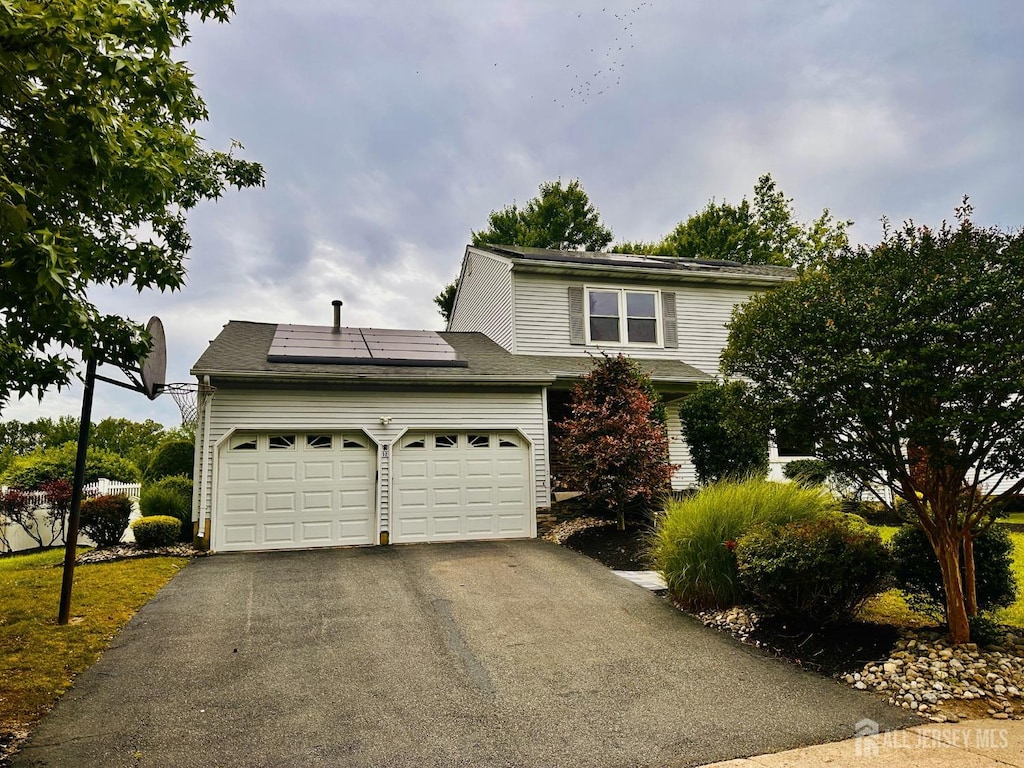 32 Wetherhill Way S, Brunswick, NJ 08810 - traditional-style house with roof mounted solar panels, driveway, and an attached garage