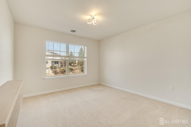 unfurnished room with baseboards, visible vents, and carpet flooring