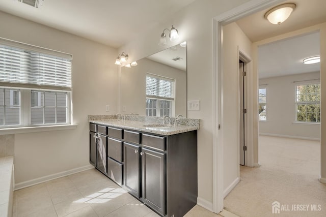 bathroom with double vanity, a sink, and a wealth of natural light