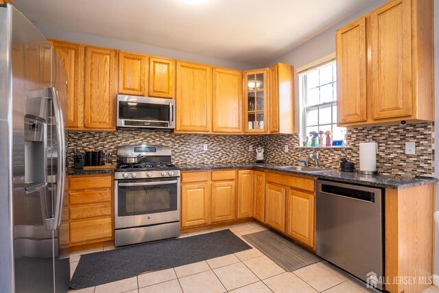 345 Morning Glory Dr, Monroe, NJ 08831 - kitchen with stainless steel appliances, a sink, backsplash, light tile patterned floors, and glass insert cabinets