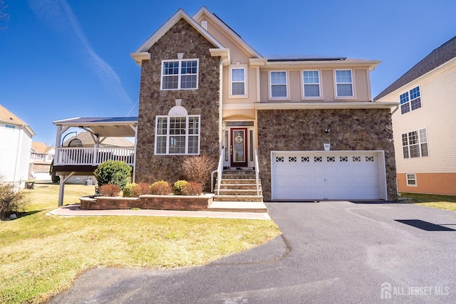 345 Morning Glory Dr, Monroe, NJ 08831 - traditional home featuring a garage, solar panels, stone siding, and aphalt driveway