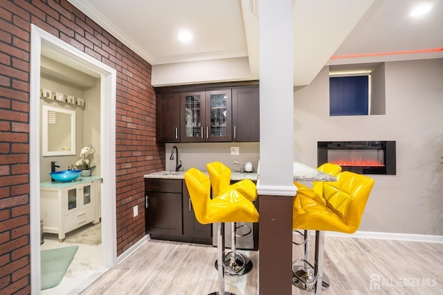 345 Morning Glory Dr, Monroe, NJ 08831 - bar with light wood-style floors, ornamental molding, brick wall, and a sink