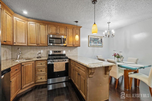 135 Hatfield Ln, East Brunswick, NJ 08816 - kitchen featuring a sink, a peninsula, backsplash, appliances with stainless steel finishes, and dark wood finished floors