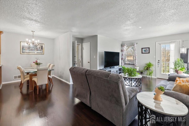 135 Hatfield Ln, East Brunswick, NJ 08816 - living area with a textured ceiling, baseboards, dark wood-style flooring, and a chandelier