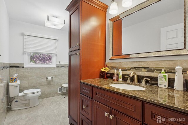 4 Franklin Ct, East Brunswick, NJ 08816 - bathroom featuring toilet, tile walls, vanity, and wainscoting