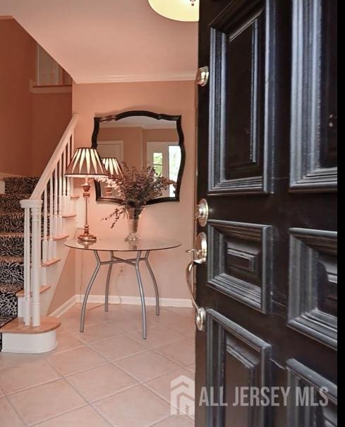 17 SE Candle Ln, East Brunswick, NJ 08816 - foyer entrance featuring crown molding, baseboards, stairs, and light tile patterned flooring