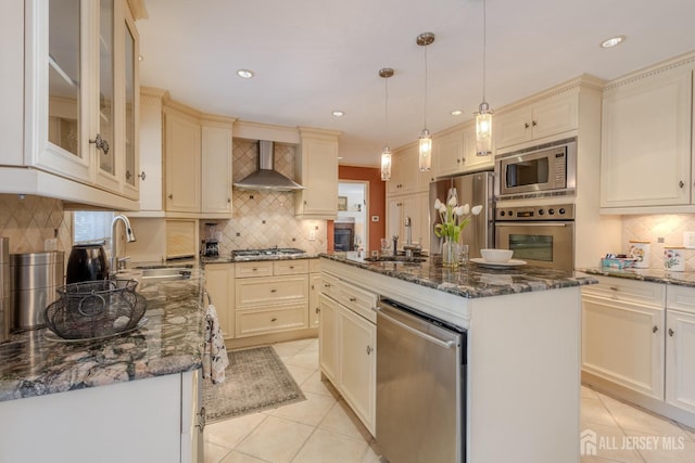 17 SE Candle Ln, East Brunswick, NJ 08816 - kitchen with wall chimney range hood, decorative backsplash, appliances with stainless steel finishes, a sink, and cream cabinetry