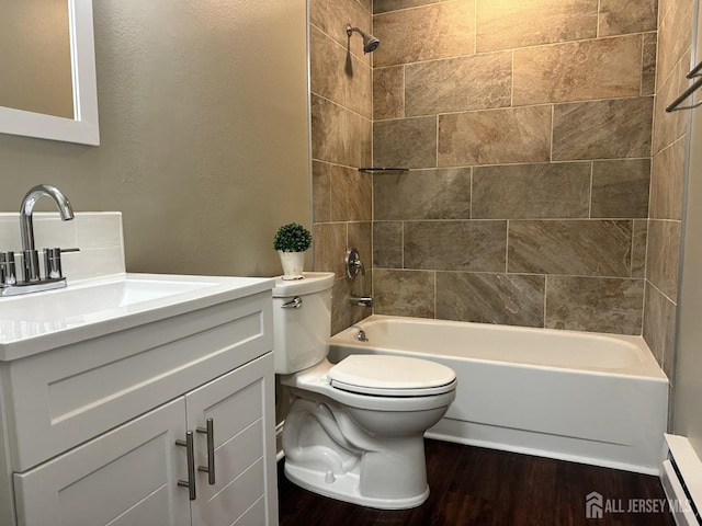 bathroom with a baseboard heating unit, toilet, bathing tub / shower combination, wood finished floors, and vanity