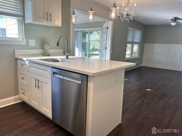 kitchen featuring a sink, light countertops, a textured ceiling, dishwasher, and open floor plan