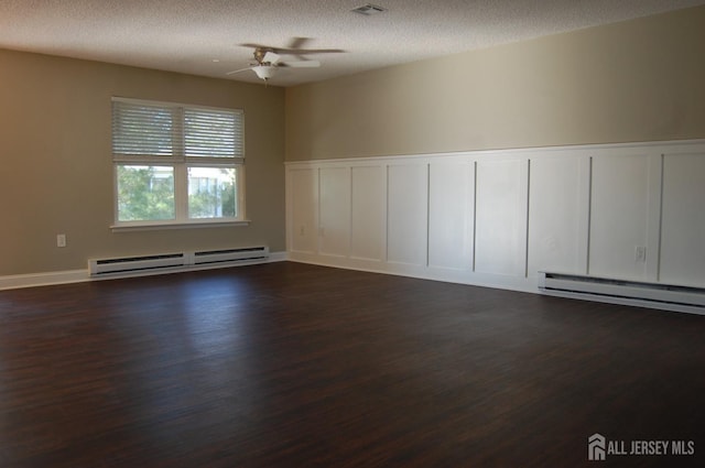 unfurnished room featuring a ceiling fan, a textured ceiling, a decorative wall, baseboard heating, and dark wood-style flooring