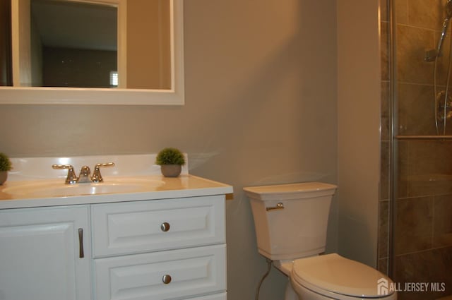 full bathroom featuring vanity, toilet, and a tile shower