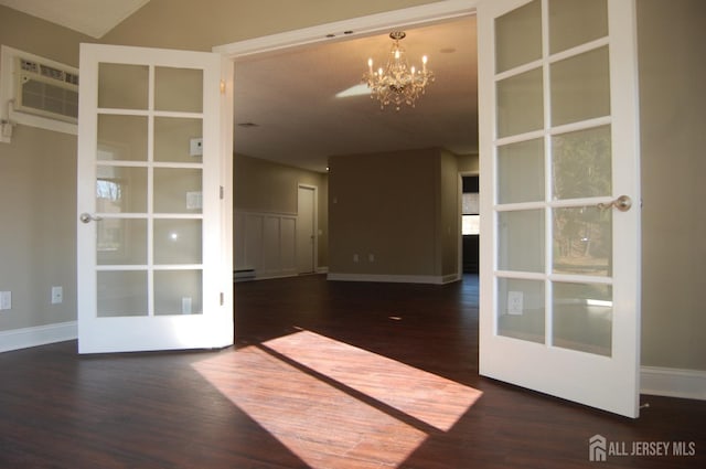 unfurnished room with a notable chandelier, a baseboard heating unit, a wall mounted AC, and wood finished floors