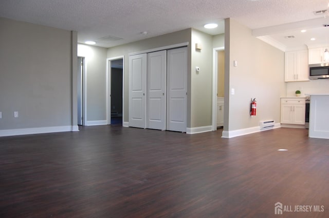 unfurnished living room with baseboards, a textured ceiling, and dark wood-style flooring