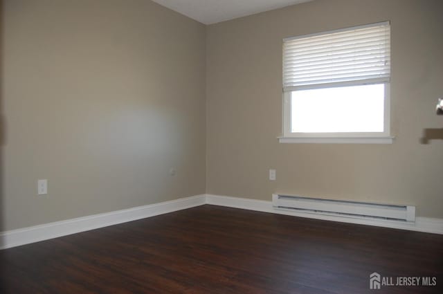 spare room with a baseboard radiator, baseboards, and wood finished floors