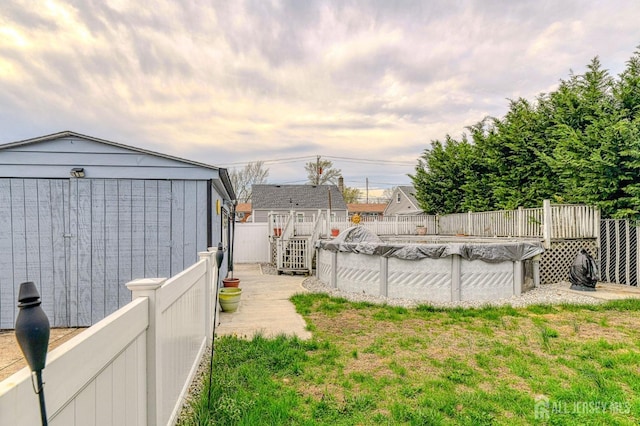view of yard featuring a storage shed, a wooden deck, and an outdoor structure