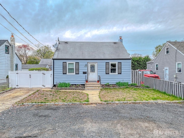 view of front of property with a gate and roof with shingles