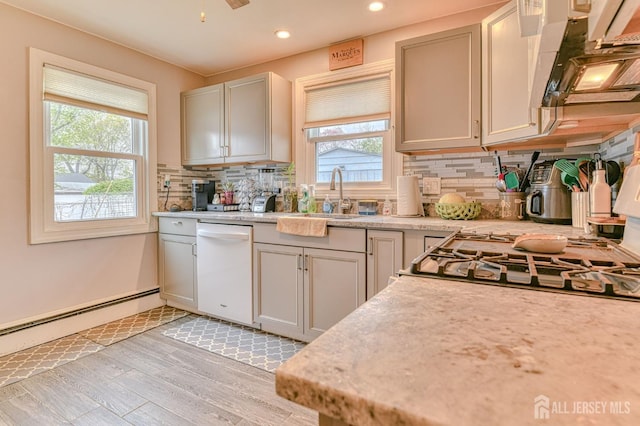 kitchen featuring dishwasher, light wood-style floors, light countertops, backsplash, and recessed lighting