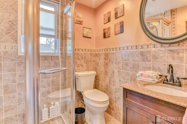 9 Macarthur Ave, Spotswood, NJ 08884 - full bathroom featuring healthy amount of natural light, tile walls, a shower stall, toilet, and wainscoting