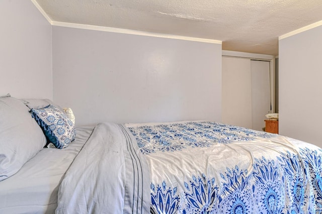 bedroom with crown molding, a textured ceiling, and a closet
