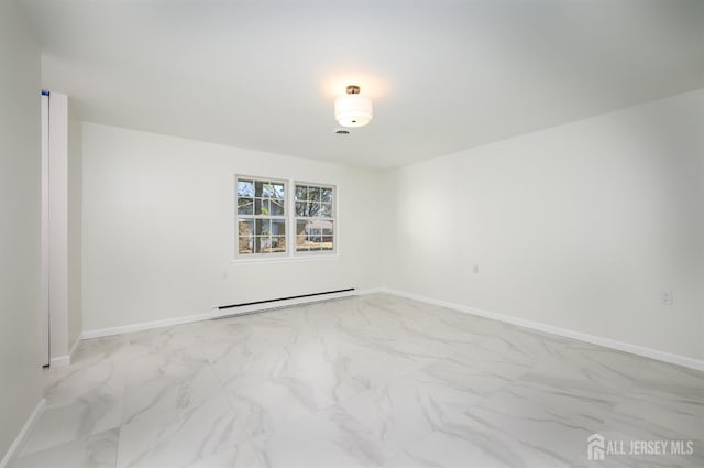 empty room featuring a baseboard heating unit, baseboards, and marble finish floor