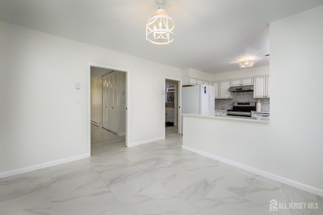 kitchen with tasteful backsplash, under cabinet range hood, stainless steel range with electric cooktop, freestanding refrigerator, and marble finish floor